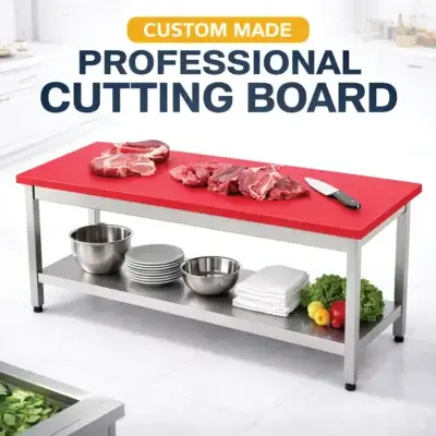 Red polyethylene cutting board with stainless steel table for commercial kitchen food preparation.