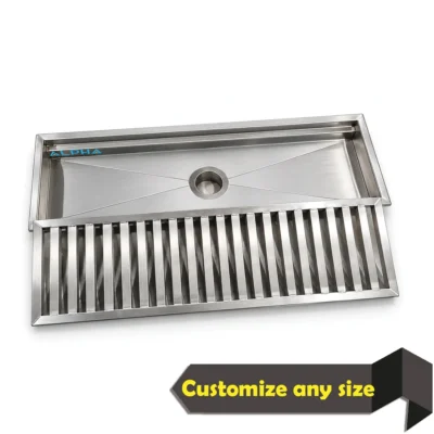 Stainless steel floor trough drain with removable bar grating and central outlet for commercial kitchens.
